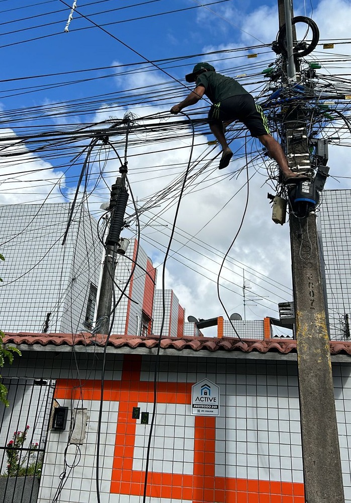 Homem é flagrado pendurado em cima de poste para roubar fios 